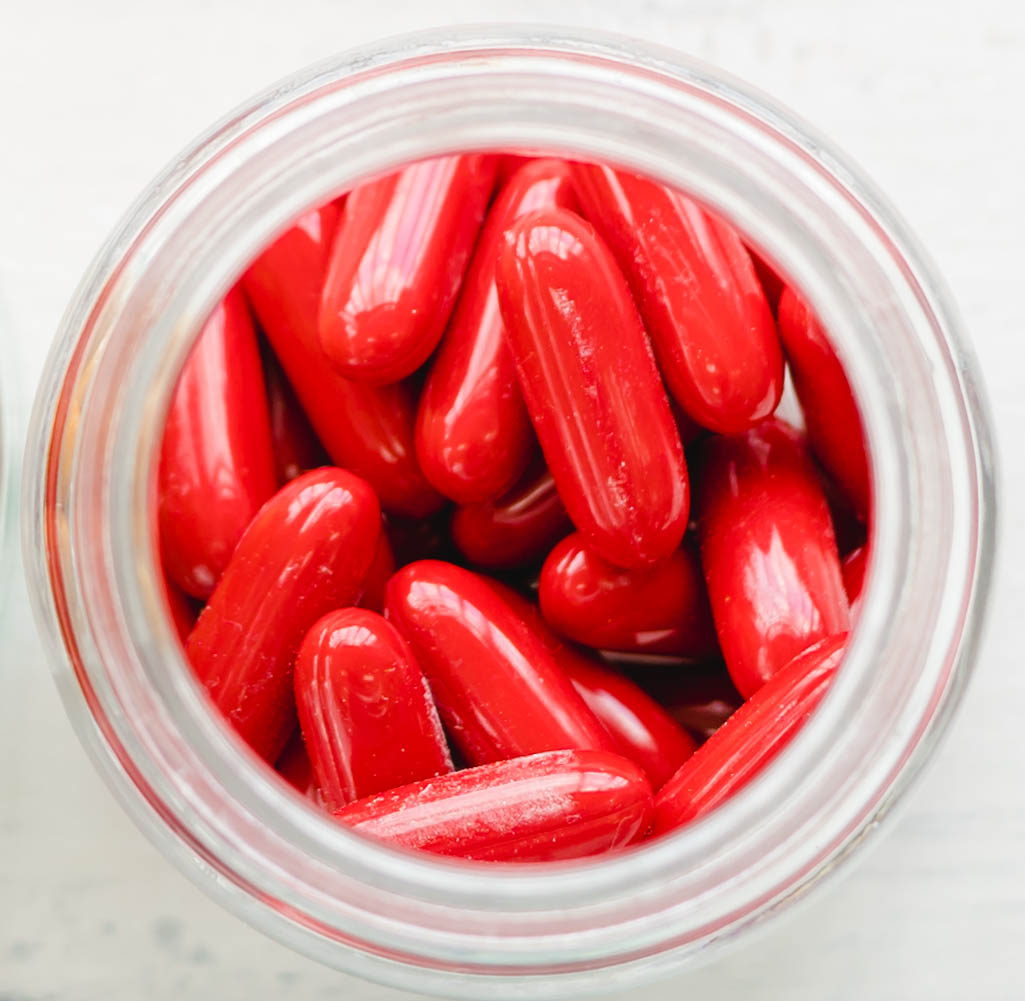 Colorful assorted pharmaceutical medicine pills, tablets and capsules and bottle on white wooden background.Capsules Vitamin And Dietary Supplements.